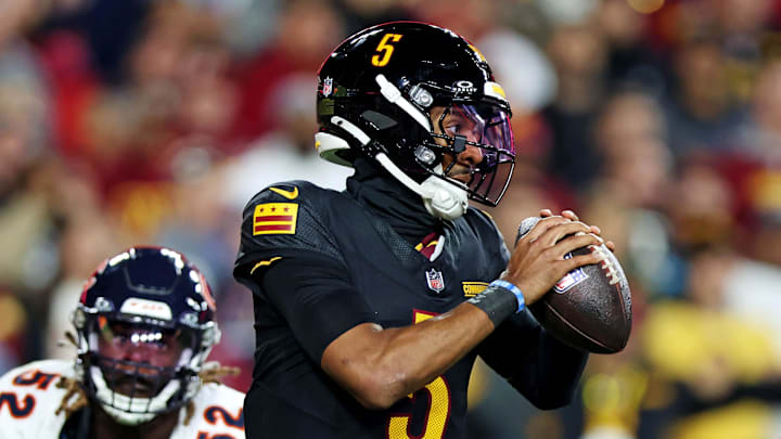 Oct 27, 2024; Landover, Maryland, USA; Washington Commanders quarterback Jayden Daniels (5) scrambles out of the pocket against Chicago Bears defensive end Darrell Taylor (52) during the second half at Commanders Field. Mandatory Credit: Peter Casey-Imagn Images