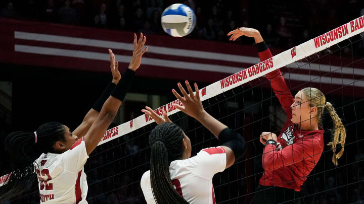 Wisconsin middle blocker Carter Booth and opposite Devyn Robinson attempt to block the shot from Nebraska middle blocker Andi Jackson 