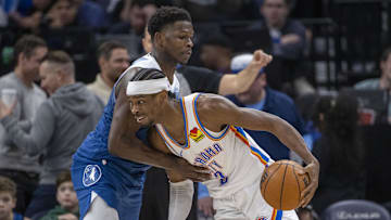 Oklahoma City Thunder guard Shai Gilgeous-Alexander dribbles the ball past Minnesota Timberwolves guard Anthony Edwards.