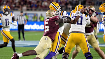 Sep 3, 2023; Orlando, Florida, USA; LSU Tigers quarterback Jayden Daniels (5) is sacked by Florida State Seminoles defensive end Jared Verse (5) during the game at Camping World Stadium. Mandatory Credit: Melina Myers-Imagn Images