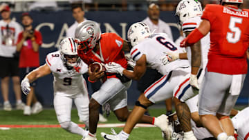 Aug 31, 2024; Tucson, Arizona, USA; New Mexico quarterback Devon Dampier (4) runs ball for a touch while Arizona Wildcats defensive back Gunner Maldonado (9) and Arizona Wildcats linebacker Taye Brown (6) try to tackle him during second quarter at Arizona Stadium. Mandatory Credit: Aryanna Frank-Imagn Images