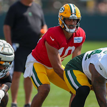 Green Bay Packers quarterback Jordan Love (10) takes a snap from offensive lineman Elgton Jenkins (74) at training camp.