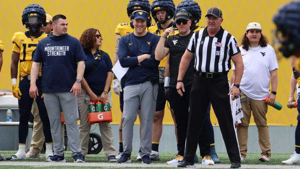 West Virginia University tight ends coach Blaine Stewart and former WVU specialist and honorary head coach Pat McAfee look on during the Gold-Blue Spring Game.