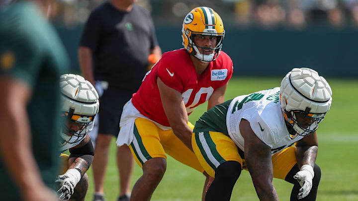 Green Bay Packers quarterback Jordan Love (10) takes a snap from offensive lineman Elgton Jenkins (74) at training camp.