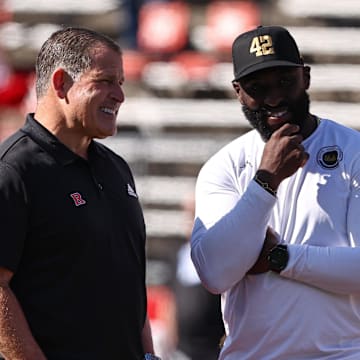 Oct 19, 2024; Piscataway, New Jersey, USA; Rutgers Scarlet Knights head coach Greg Schiano, left, talks with UCLA Bruins head coach DeShaun Foster before their Big Ten conference game at SHI Stadium. Mandatory Credit: Vincent Carchietta-Imagn Images