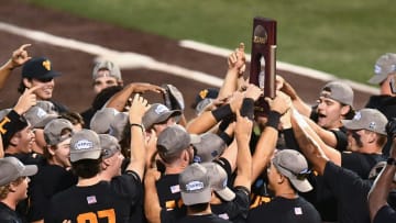 Tennessee players celebrate with their trophy after the win over Evansville in the Knoxville Super Regional of the NCAA baseball tournament on Sunday, June 9, 2024 in Knoxville, Tenn.
