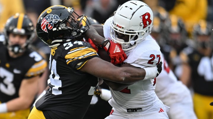 Nov 11, 2023; Iowa City, Iowa, USA; Iowa Hawkeyes linebacker Jay Higgins (34) tackles Rutgers Scarlet Knights running back Samuel Brown V (27) during the game at Kinnick Stadium. Mandatory Credit: Jeffrey Becker-USA TODAY Sports