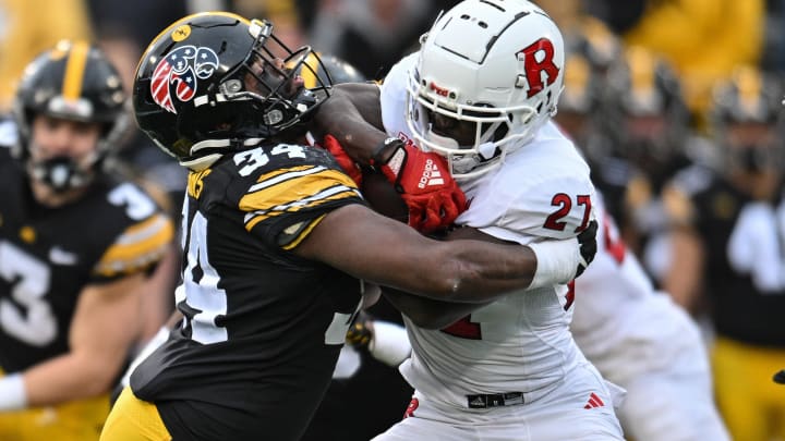 Nov 11, 2023; Iowa City, Iowa, USA; Iowa Hawkeyes linebacker Jay Higgins (34) tackles Rutgers Scarlet Knights running back Samuel Brown V (27) during the game at Kinnick Stadium. Mandatory Credit: Jeffrey Becker-USA TODAY Sports