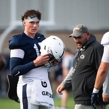 Penn State Nittany Lions quarterback Drew Allar puts his helmet on during a practice session outside Holuba Hall.