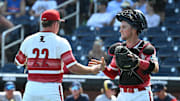 Jun 15, 2025; Omaha, Neb, USA;  Louisville Cardinals pitcher Tucker Biven (22) and Louisville Cardinals catcher Matt Klein (25) celebrate the win against the Arizona Wildcats at Charles Schwab Field. Mandatory Credit: Steven Branscombe-Imagn Images