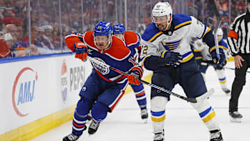 Dec 7, 2024; Edmonton, Alberta, CAN; Edmonton Oilers forward Mattias Janmark (13) and St. Louis Blues defensemen Justin Faulk (72) chase a loose puck during the third period at Rogers Place. Mandatory Credit: Perry Nelson-Imagn Images