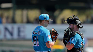 Feb 28, 2025; Jupiter, Florida, USA; Miami Marlins catcher Liam Hicks (34) talks to relief pitcher Robby Snelling (61) against the Atlanta Braves during the fourth inning at Roger Dean Chevrolet Stadium. Mandatory Credit: Sam Navarro-Imagn Images
