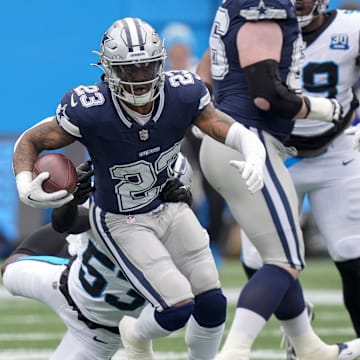 Dec 15, 2024; Charlotte, North Carolina, USA; Dallas Cowboys running back Rico Dowdle (23) runs out of a tackle by Carolina Panthers linebacker Claudin Cherelus (53) during the first quarter at Bank of America Stadium. Mandatory Credit: Jim Dedmon-Imagn Images