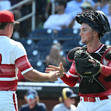 Jun 15, 2025; Omaha, Neb, USA;  Louisville Cardinals pitcher Tucker Biven (22) and Louisville Cardinals catcher Matt Klein (25) celebrate the win against the Arizona Wildcats at Charles Schwab Field. Mandatory Credit: Steven Branscombe-Imagn Images