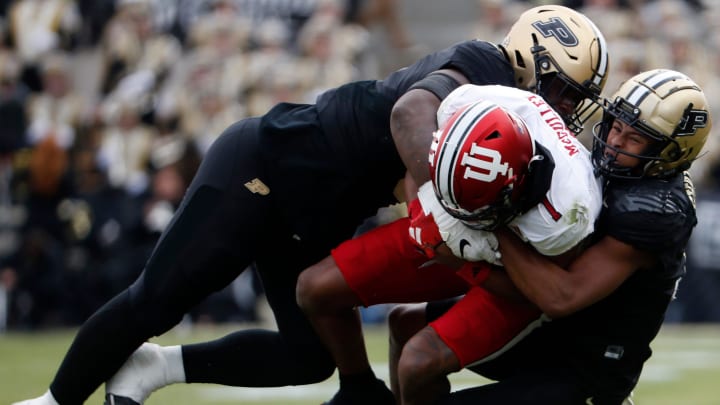 Purdue Boilermakers linebacker Nic Scourton (5) and Purdue Boilermakers defensive back Zion Steptoe (7) tackle Indiana Hoosiers wide receiver Donaven McCulley (1) during the NCAA football game, Saturday, Nov. 25, 2023, at Ross-Ade Stadium in West Lafayette, Ind.