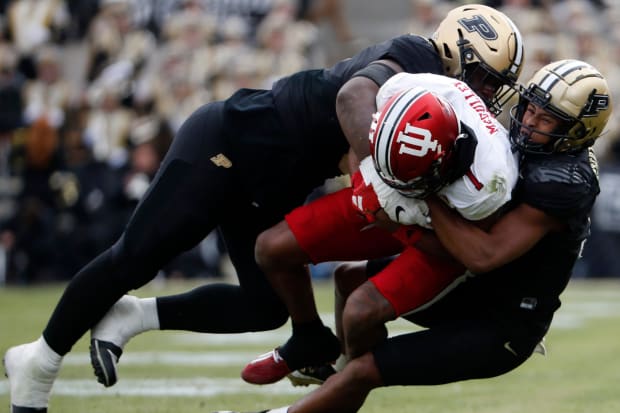 Purdue linebacker Nic Scourton and defensive back Zion Steptoe tackle Indiana receiver Donaven McCulley. 