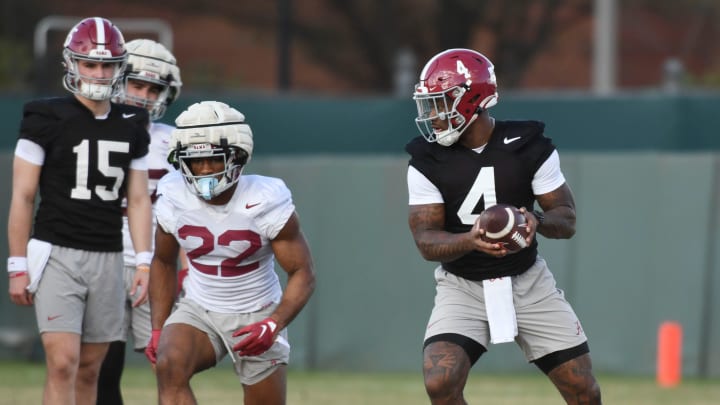 Jalen Milroe turns to hand the ball off to Justice Haynes during practice for the Alabama Crimson Tide football team. 