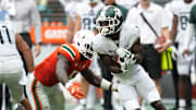 Sep 18, 2021; Miami Gardens, Florida, USA; Miami Hurricanes safety Amari Carter (5) tackles Michigan State Spartans wide receiver Ricky White (7) during the second half at Hard Rock Stadium. Mandatory Credit: Jasen Vinlove-Imagn Images