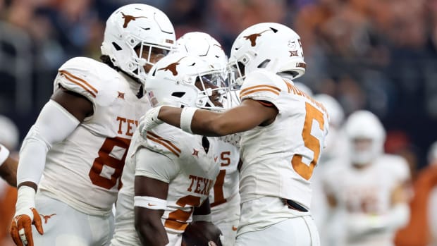 Texas's Kitan Crawford (21) celebrates an interception with Texas's Malik Muhammad (5) in the first half of the Big 12 Footba