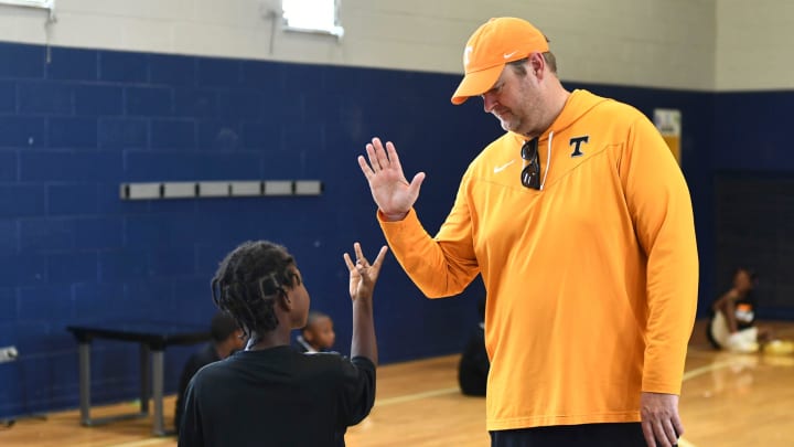 Tennesee football coach Josh Heupel's high five is returned with the Vol For Life hand sign during Camp Evolve at Walter P. Taylor Boys and Girls Club on Monday, June 17, 2024.
