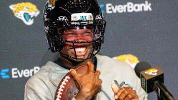 The Jacksonville Jaguars’ first-round pick, Colorado Buffaloes wide receiver and defensive back Travis Hunter sits in his chair with his helmet on and acting as if he was running after answering questions during a press conference.