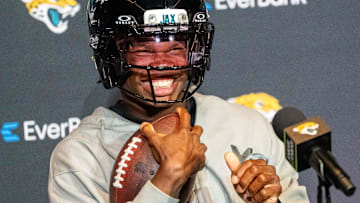 The Jacksonville Jaguars’ first-round pick, Colorado Buffaloes wide receiver and defensive back Travis Hunter sits in his chair with his helmet on and acting as if he was running after answering questions during a press conference Friday, March 25, 2025 at Miller Electric Center in Jacksonville, Fla.
