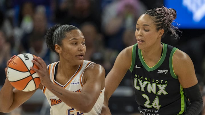 Sep 21, 2025; Minneapolis, Minnesota, USA; Phoenix Mercury forward Alyssa Thomas (25) holds the ball as Minnesota Lynx forward Napheesa Collier (24) plays defense in the first half during game one of the second round for the 2025 WNBA Playoffs at Target Center. Mandatory Credit: Jesse Johnson-Imagn Images