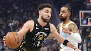 February 11, 2023; San Francisco, California, USA; Golden State Warriors guard Klay Thompson (11) dribbles the basketball against Los Angeles Lakers guard D'Angelo Russell (1) during the first quarter at Chase Center. Mandatory Credit: Kyle Terada-Imagn Images