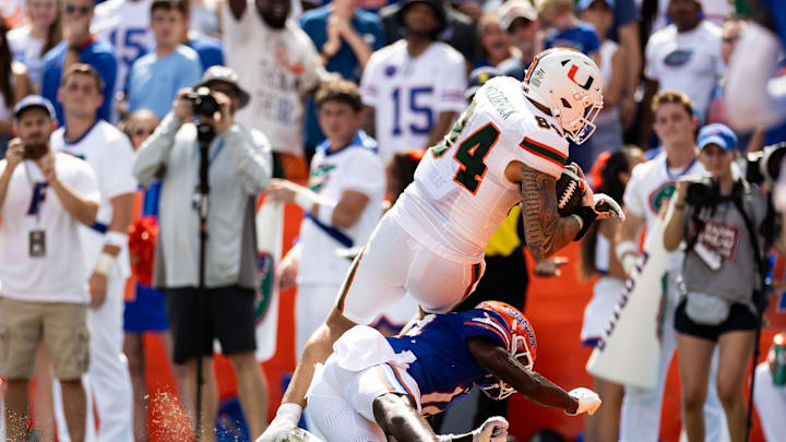 Aug 31, 2024; Gainesville, Florida, USA; Miami Hurricanes tight end Cam McCormick (84) scores a touchdown over Florida Gators defensive back Jordan Castell (14) during the first half at Ben Hill Griffin Stadium. Mandatory Credit: Matt Pendleton-Imagn Images