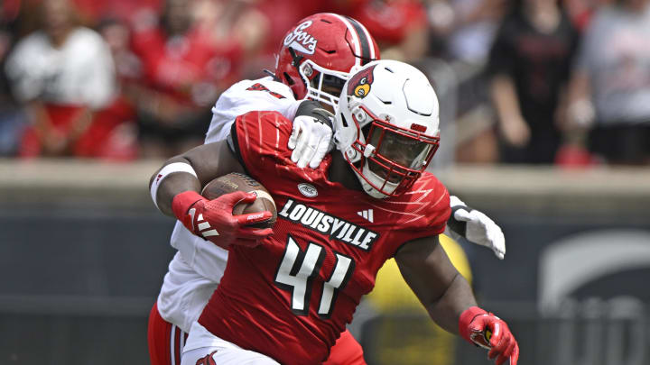 Aug 31, 2024; Louisville, Kentucky, USA;  Louisville Cardinals defensive lineman Ramon Puryear (41) returns a fumble recovery against Austin Peay Governors offensive lineman Chinazo Obobi (55) during the second half at L&N Federal Credit Union Stadium. Louisville defeated Austin Peay 62-0. Mandatory Credit: Jamie Rhodes-USA TODAY Sports