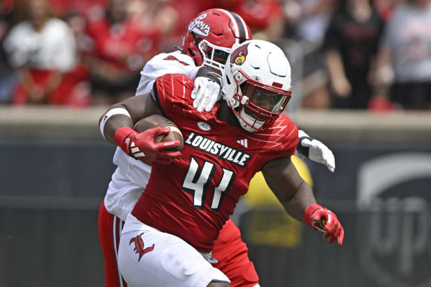 Louisville Cardinals defensive lineman Ramon Puryear (41) returns a fumble recovery 