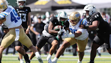 Aug 31, 2024; Honolulu, Hawaii, USA; UCLA Bruins defensive lineman Sitiveni Havili Kaufusi (95) tries to pull down Hawaii Rainbow Warriors running back Cam Barfield (9) during the second quarter of an NCAA college football game at the Clarence T.C. Ching Athletics Complex. Mandatory Credit: Marco Garcia-USA TODAY Sports