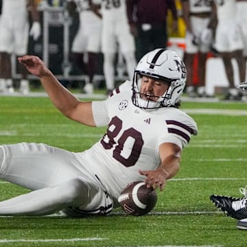 Mississippi State Bulldogs place kicker Kyle Ferrie (80) chases after a bad snap as several Missouri Tigers defenders attempt the fumble recovery during the first half of the game at Faurot Field at Memorial Stadium.