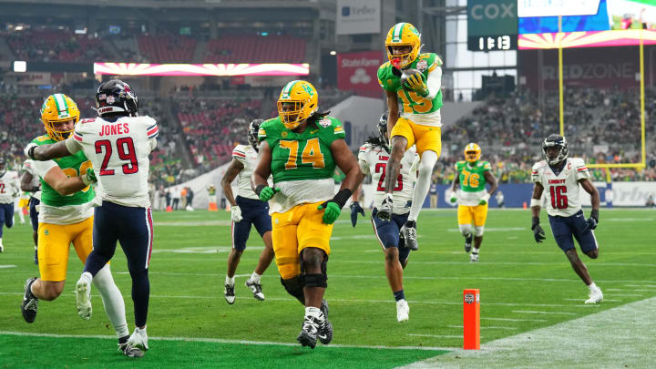 Jan 1, 2024; Glendale, AZ, USA; Oregon Ducks wide receiver Tez Johnson (15) leaps into the end zone for a touchdown against the Liberty Flames during the second half in the 2024 Fiesta Bowl at State Farm Stadium.