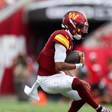 Sep 8, 2024; Tampa, Florida, USA; Washington Commanders quarterback Jayden Daniels (5) runs with the ball against the Tampa Bay Buccaneers in the second quarter at Raymond James Stadium. Mandatory Credit: Nathan Ray Seebeck-Imagn Images