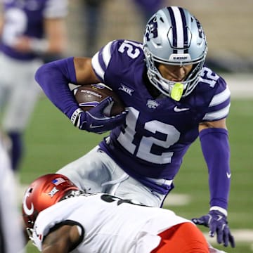 Nov 23, 2024; Manhattan, Kansas, USA; Kansas State Wildcats wide receiver Tre Spivey (12) is tackled by Cincinnati Bearcats cornerback Ormanie Arnold (8) during the third quarter at Bill Snyder Family Football Stadium. Mandatory Credit: Scott Sewell-Imagn Images