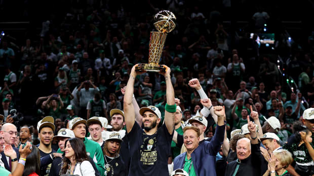 Boston Celtics forward Jayson Tatum (0) lifts the Larry O’Brien Trophy after winning the 2024 NBA championship.