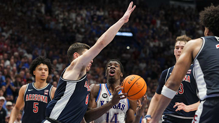 Feb 9, 2026; Lawrence, Kansas, USA; Kansas Jayhawks guard Melvin Council Jr. (14) drives against Arizona Wildcats forward Ivan Kharchenkov (8) during the second half at Allen Fieldhouse. Mandatory Credit: Jay Biggerstaff-Imagn Images