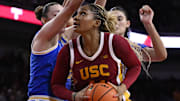 Feb 13, 2025; Los Angeles, California, USA; USC Trojans forward Kiki Iriafen (44) drives to the basket as UCLA Bruins forward Angela Dugalic (left) and UCLA Bruins center Lauren Betts (51) defend during the third quarter at Galen Center. Mandatory Credit: Robert Hanashiro-Imagn Images