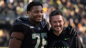 Oregon’s Isaiah World, left, takes a picture with coach Dan Lanning before the game against Southern California Nov. 22, 2025.