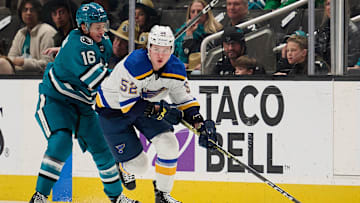 Apr 6, 2024; San Jose, California, USA; St. Louis Blues center Zach Dean (52) plays the puck against San Jose Sharks center Jack Studnicka (16) during the first period at SAP Center at San Jose. Mandatory Credit: Robert Edwards-Imagn Images