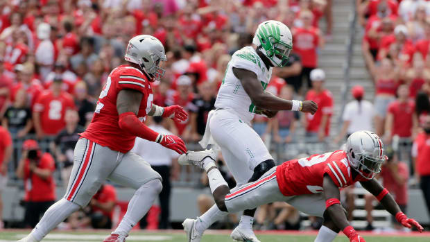 Oregon Ducks quarterback Anthony Brown (13) is pursued by Ohio State Buckeyes defensive tackle Haskell Garrett (92) and Ohio 