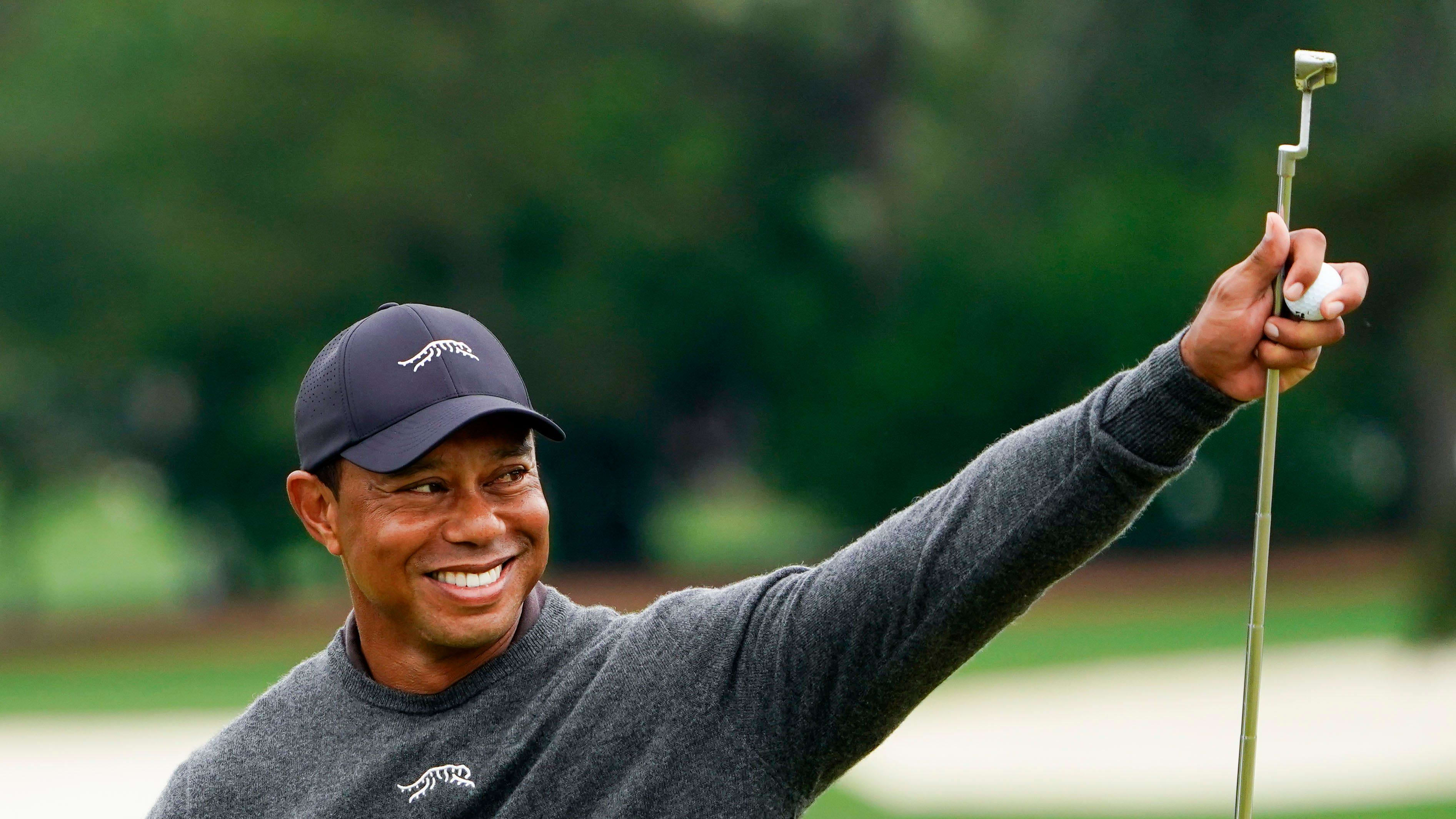 Tiger Woods gives a thumbs up to the crowd on the No. 9 green during a practice round.