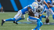 Sep 15, 2024; Charlotte, North Carolina, USA; Los Angeles Chargers cornerback Asante Samuel Jr. (26) tackles Carolina Panthers defensive end LaBryan Ray (93) during the second half at Bank of America Stadium. 