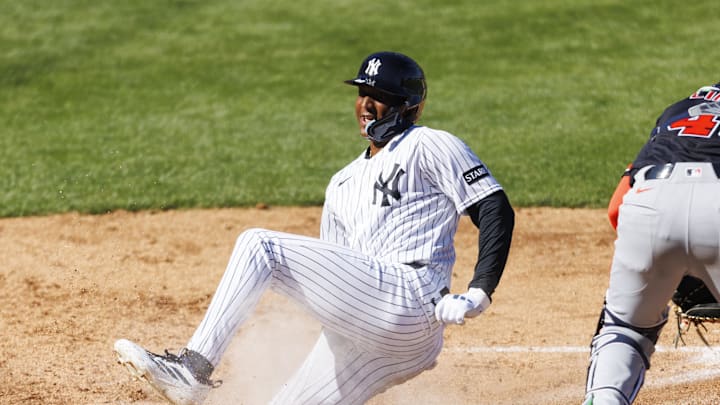 Feb 21, 2026; Tampa, Florida, USA; New York Yankees outfielder Marco Luciano (60) slides into home plate before Detroit Tigers catcher Thayron Liranzo (49) during the sixth inning in a Spring Training game at George M. Steinbrenner Field. Mandatory Credit: Morgan Tencza-Imagn Images