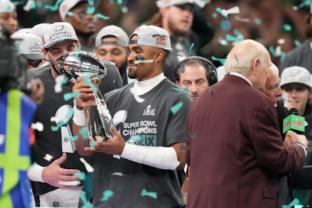 Philadelphia Eagles'Jalen Hurts hoists the Vince Lombardi Trophy after defeating the Kansas City Chiefs in Super Bowl LIX.