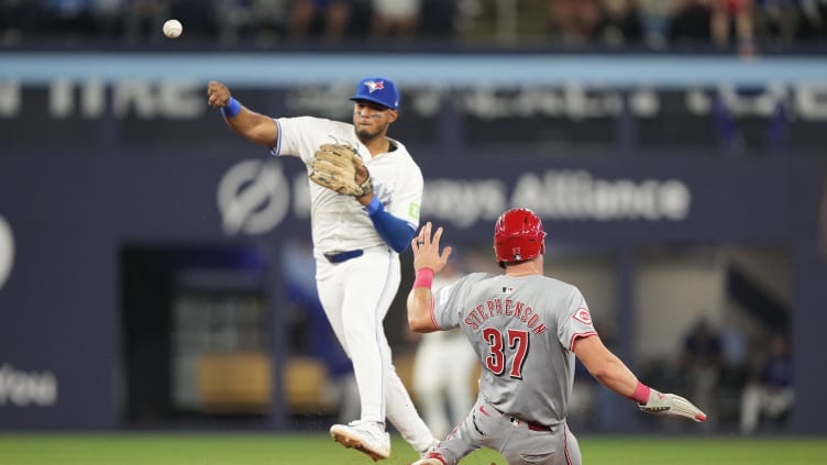 Aug 20, 2024; Toronto, Ontario, CAN; Toronto Blue Jays shortstop Leo Jimenez (49) throws to first base after getting Cincinnati Reds catcher Tyler Stephenson (37) out at second base during the eighth inning at Rogers Centre. Mandatory Credit: John E. Sokolowski-USA TODAY Sports