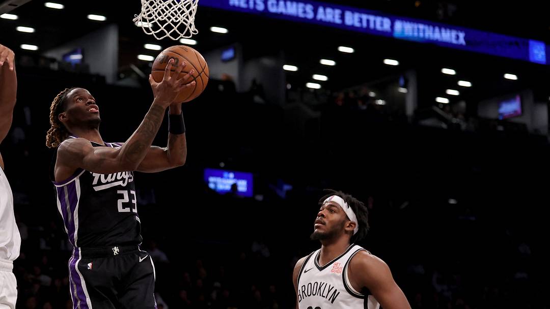Jan 27, 2025; Brooklyn, New York, USA; Sacramento Kings guard Keon Ellis (23) drives to the basket against Brooklyn Nets guard Reece Beekman (4) and center Day'Ron Sharpe (20) during the fourth quarter at Barclays Center. Mandatory Credit: Brad Penner-Imagn Images