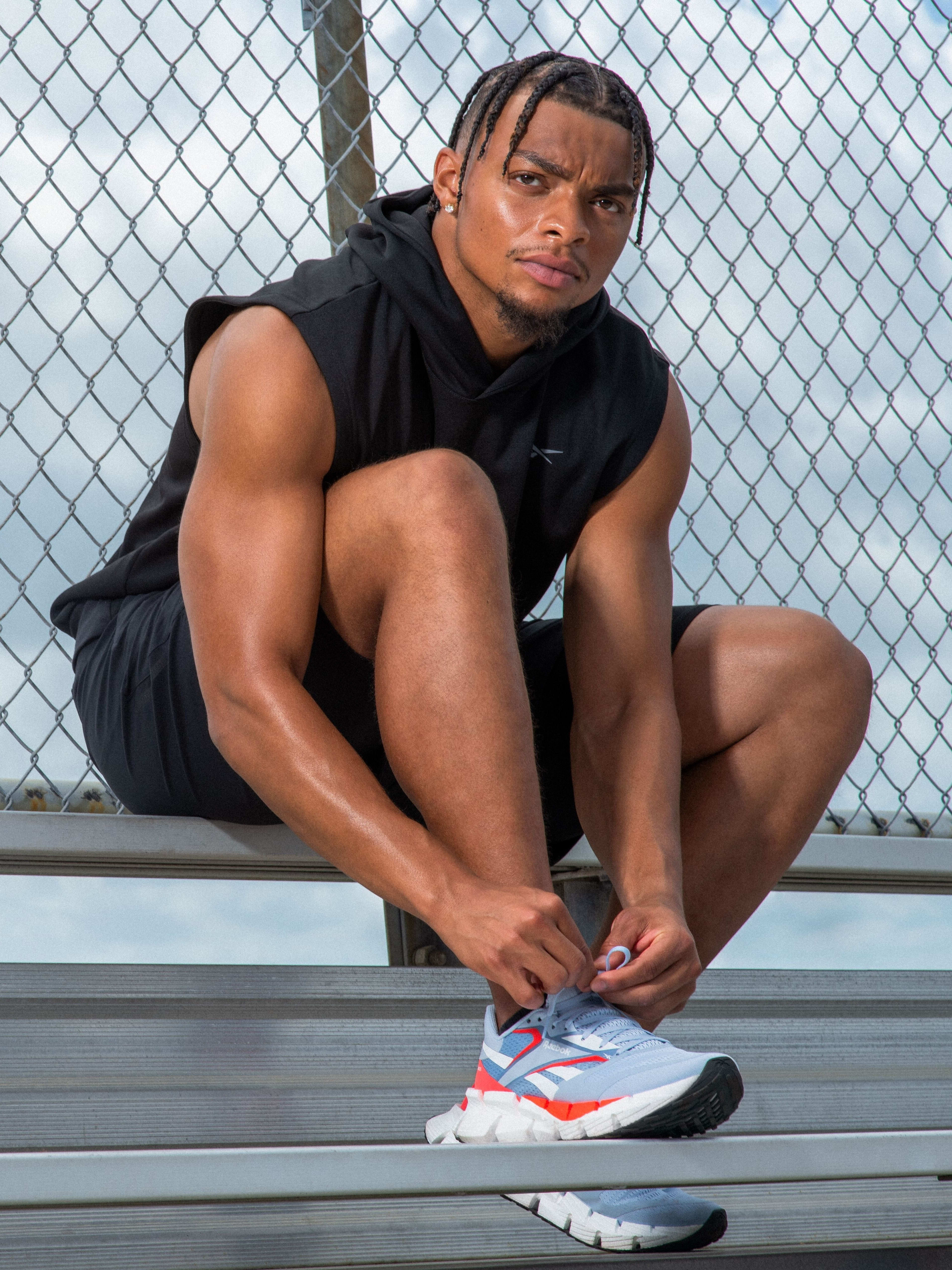 Justin Fields poses white blue Reebok sneakers.