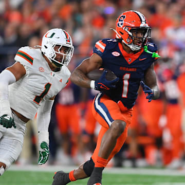 Nov 30, 2024; Syracuse, New York, USA; Syracuse Orange running back LeQuint Allen (1) runs with the ball against Miami Hurricanes linebacker Francisco Mauigoa (1) during the second half at the JMA Wireless Dome